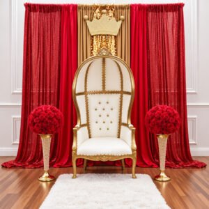 Ivory and gold royal throne chair with red and gold draping, decorative crown, and red floral centerpieces for a Long Island party rental