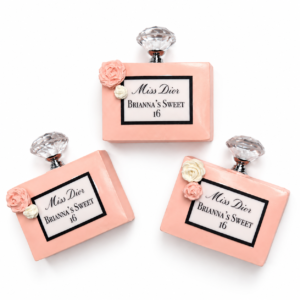 Three pink perfume bottle chocolate covered Rice Krispie treats with personalized Sweet 16 labels, roses and crystal-style toppers