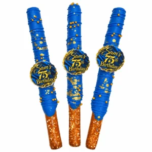 Custom blue and gold chocolate covered pretzel rods with personalized 75th birthday edible toppers and gold sprinkles