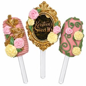 Enchanted floral mini cakesicles decorated with pink and ivory roses, green vines, and ornate gold Sweet 16 frame.