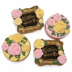 Enchanted floral chocolate covered Oreos decorated with pink and yellow roses, green vines, and ornate gold Sweet 16 frames.