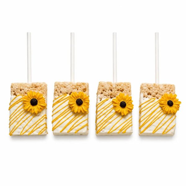 Four sunflower chocolate covered Rice Krispie treats on sticks with white coating, yellow drizzle and yellow sunflower decorations